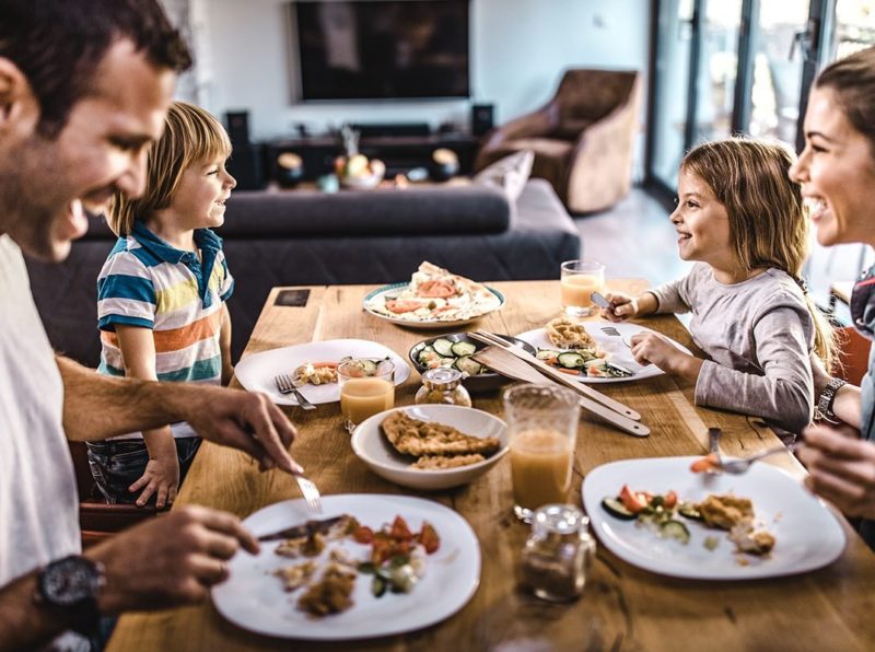 family gathered around the table laughing and eating