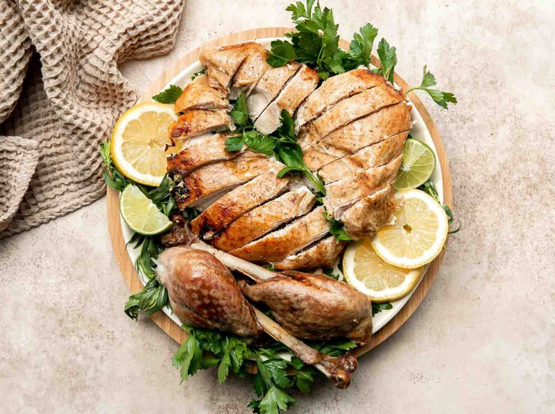 sliced turkey on a platter with lemon slices