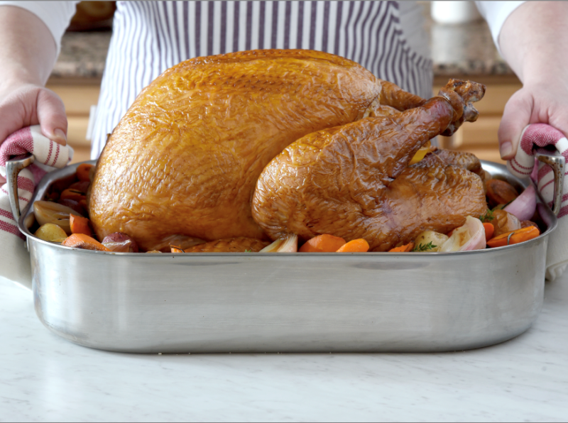 roasted turkey in a pan with vegetables