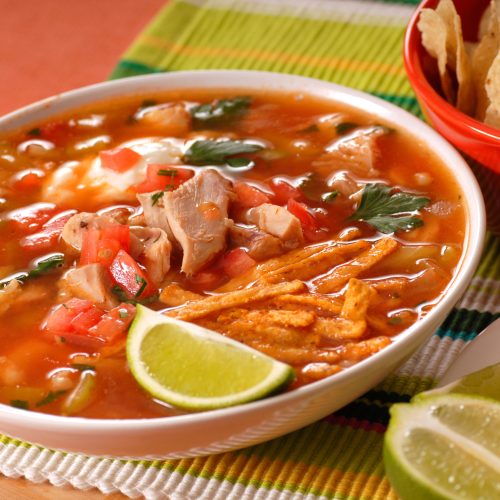 Bowl of chicken and tortilla soup with lime