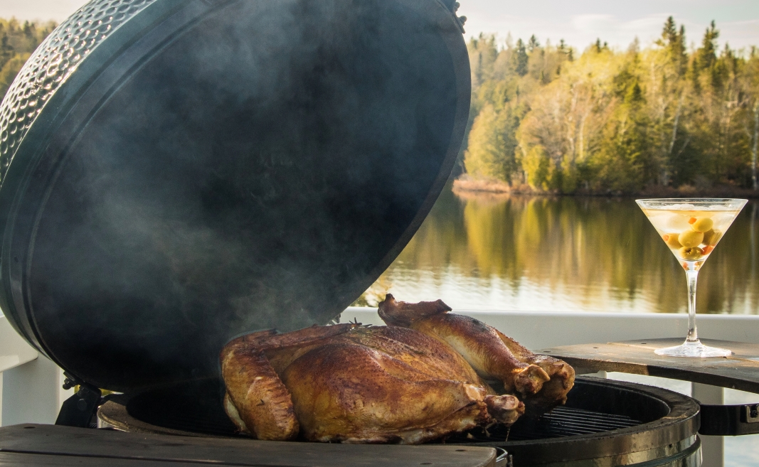 Maple & Herbs Smoked Spatchcock Turkey on the grill overlooking a lake