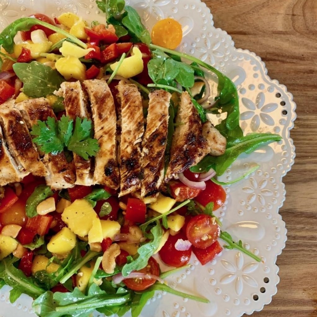 Marinated Turkey Salad with Arugula, Mango and Cashew on a plate