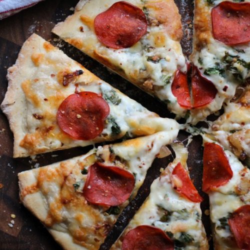 Turkey pepperoni pizza with caramelized onions and wilted kale