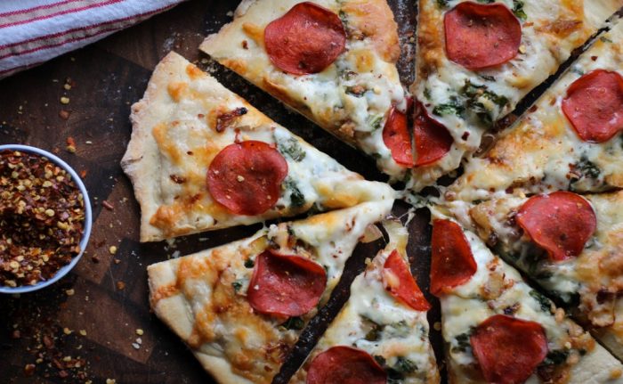 Turkey pepperoni pizza with caramelized onions and wilted kale