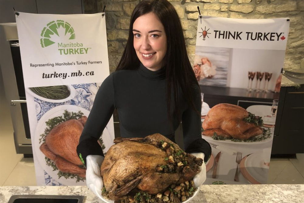 representative for Manitoba Turkey farmers holding a cooked turkey