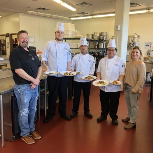 chefs standing with judges presenting their dishes
