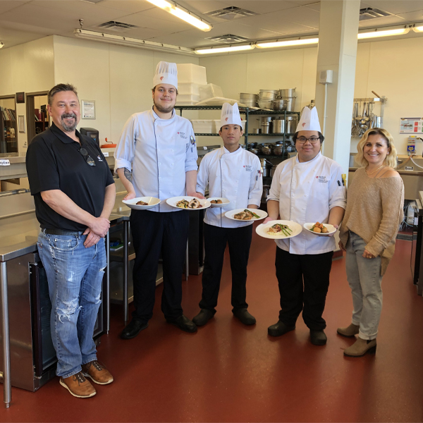 chefs standing with judges presenting their dishes