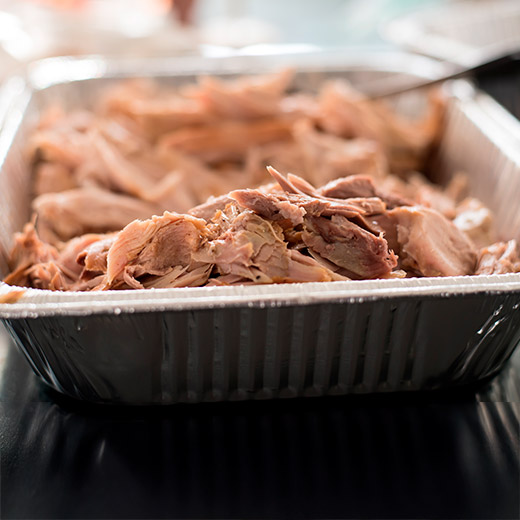 cooked and deboned turkey pieces in a foil pan